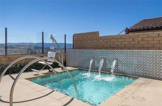 view of swimming pool with a community hot tub and a mountain view
