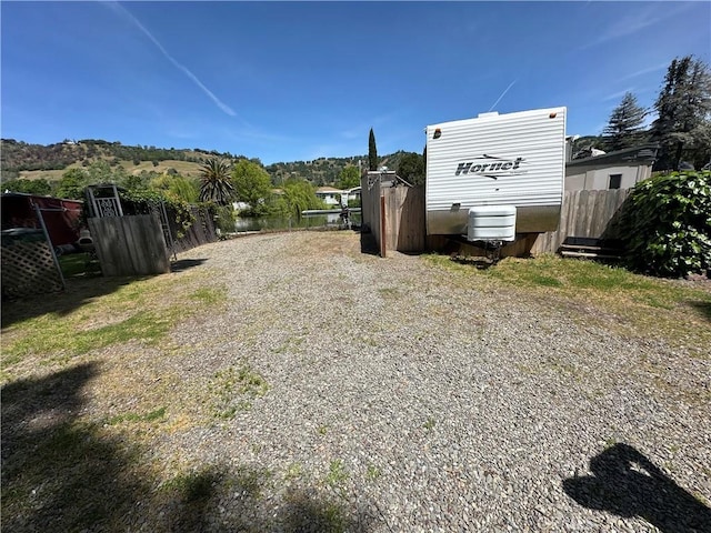 view of yard with a water view and fence