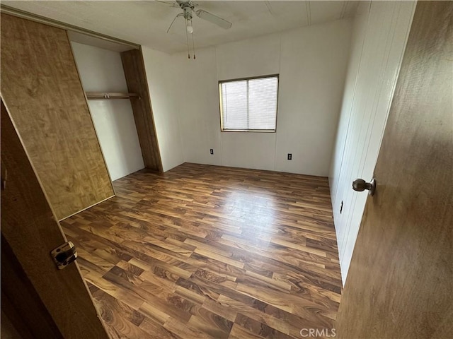 unfurnished bedroom with a closet, dark wood finished floors, and ceiling fan