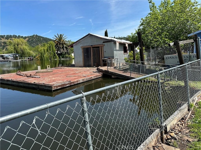 dock area with fence and a water view