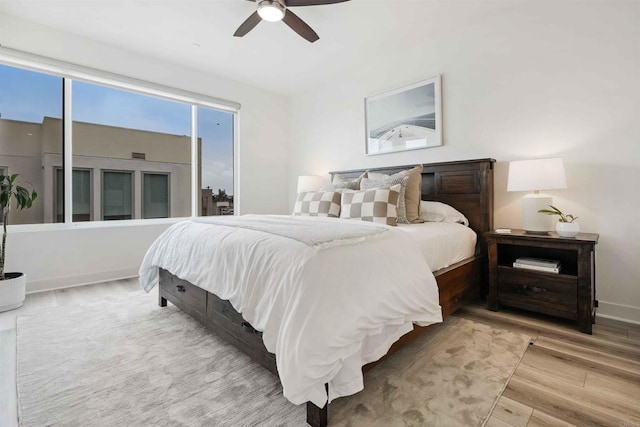 bedroom featuring a ceiling fan, baseboards, and wood finished floors