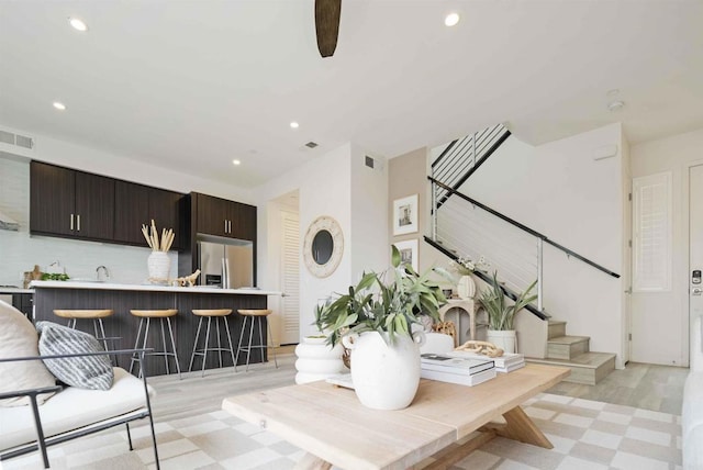 living area featuring recessed lighting, visible vents, stairway, and light floors