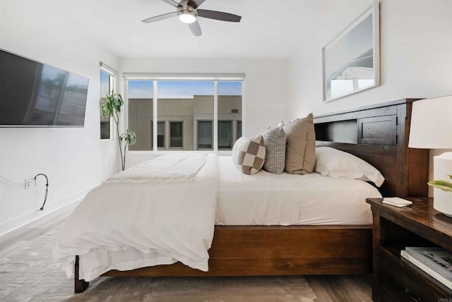 bedroom featuring baseboards, ceiling fan, wood finished floors, and access to exterior