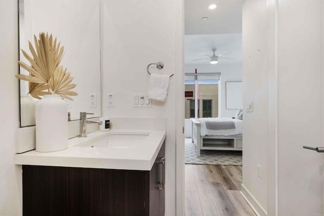 ensuite bathroom featuring ensuite bath, vanity, a ceiling fan, recessed lighting, and wood finished floors
