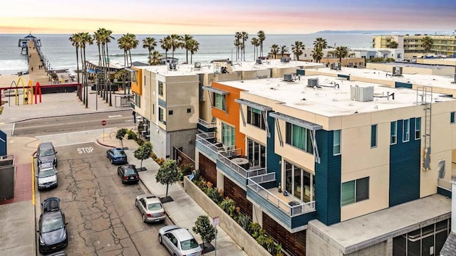 property at dusk featuring a water view and ac unit