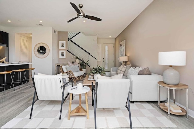 living room with stairway, recessed lighting, and light wood-type flooring