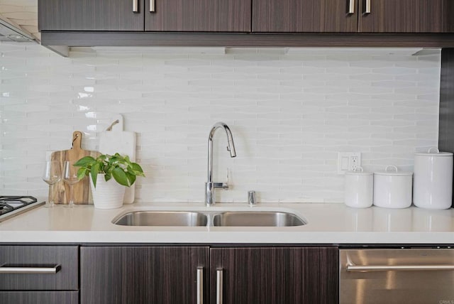 kitchen featuring stainless steel dishwasher, light countertops, a sink, and tasteful backsplash
