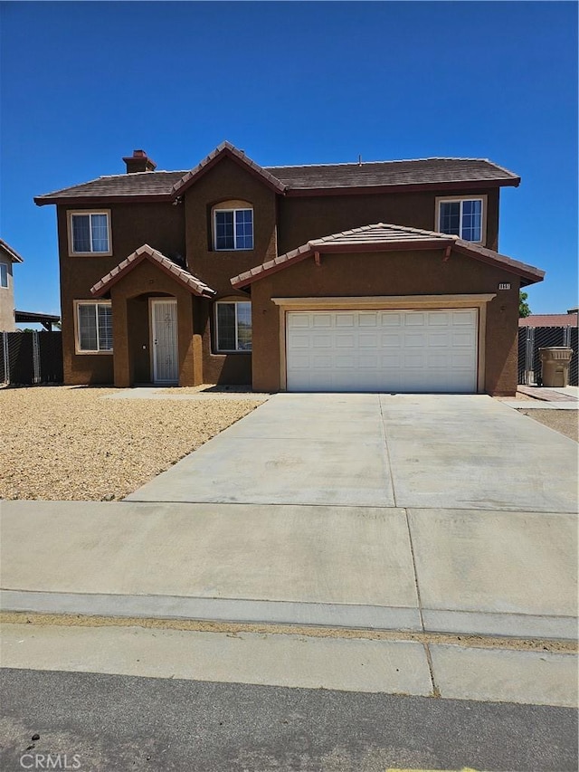 view of front facade with an attached garage, stucco siding, driveway, and a tile roof