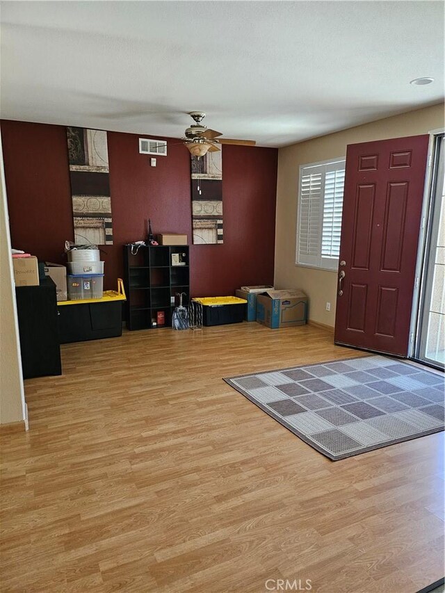 foyer featuring visible vents, a ceiling fan, and wood finished floors