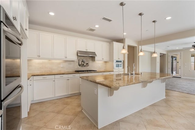44557 Howell Mountain St, Temecula, CA 92592 - kitchen featuring decorative backsplash, stovetop, visible vents, a sink, and stone countertops