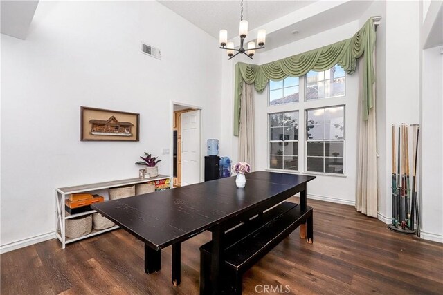 dining space with baseboards, an inviting chandelier, wood finished floors, and visible vents