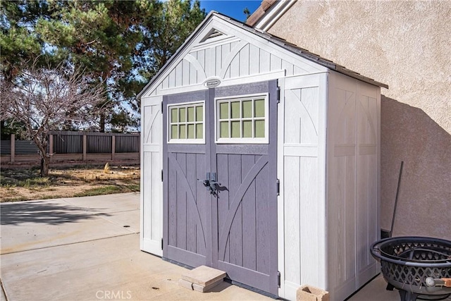 view of shed featuring fence