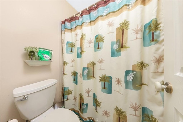 bathroom with a shower with shower curtain and toilet