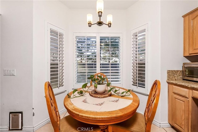 dining room featuring an inviting chandelier, baseboards, and a toaster