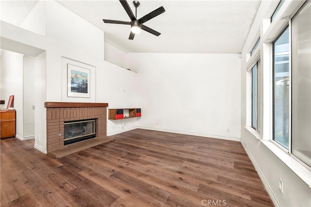 unfurnished living room with a healthy amount of sunlight, lofted ceiling, and wood finished floors