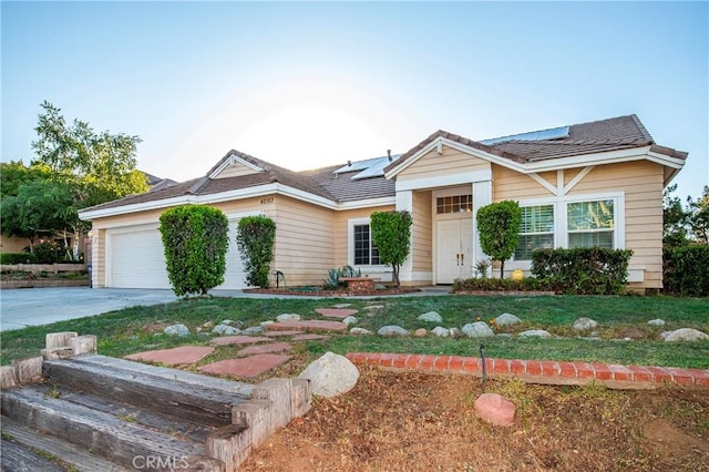 ranch-style home featuring concrete driveway, an attached garage, and roof mounted solar panels