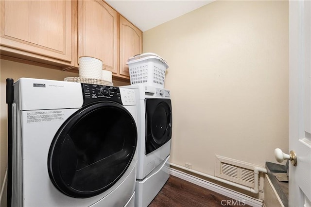 clothes washing area featuring cabinet space, separate washer and dryer, dark wood finished floors, baseboards, and visible vents
