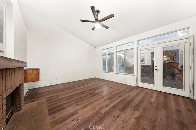 unfurnished living room with plenty of natural light, a ceiling fan, french doors, a fireplace, and wood finished floors