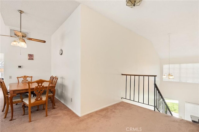 carpeted dining space featuring baseboards, ceiling fan with notable chandelier, vaulted ceiling, and visible vents