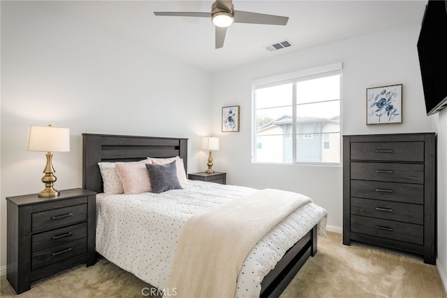 bedroom with light colored carpet, baseboards, and a ceiling fan