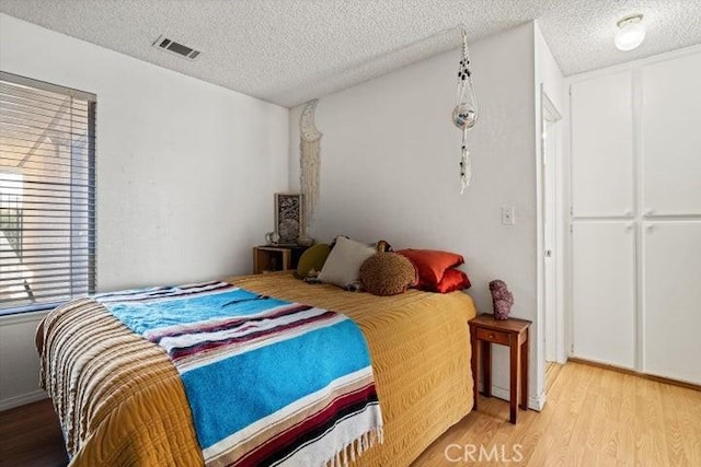 2129 El Domingo Cir Unit 19, Lancaster, CA 93536 - bedroom with light wood-type flooring, a textured ceiling, and visible vents