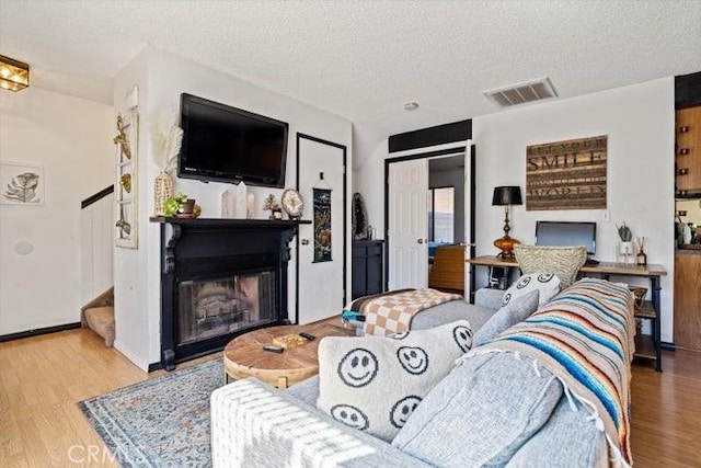 2129 El Domingo Cir Unit 19, Lancaster, CA 93536 - living area with a textured ceiling, visible vents, wood finished floors, and a fireplace