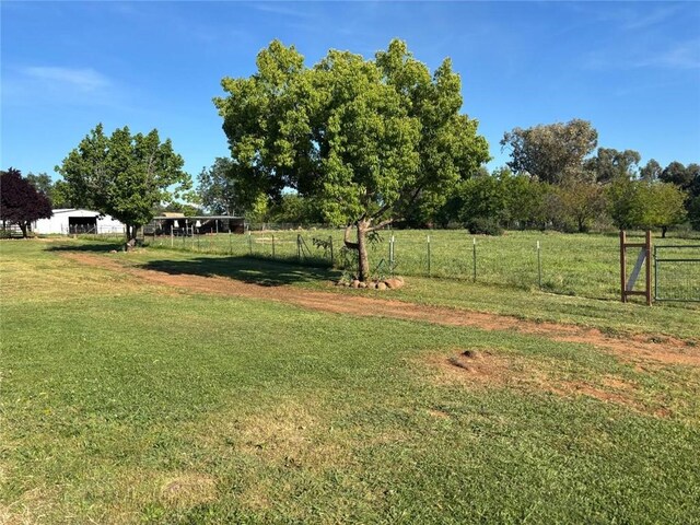 view of yard featuring fence and a rural view