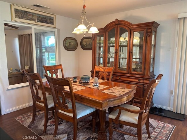 dining space featuring baseboards, visible vents, and dark wood finished floors