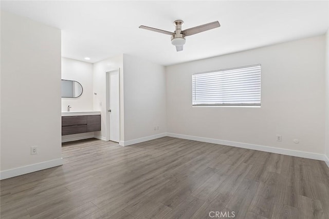 5461 Newcastle Ave Unit 14, Encino, CA 91316 - unfurnished living room featuring baseboards, a ceiling fan, and wood finished floors