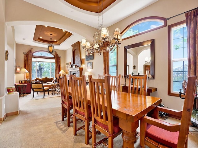 508 Lantern Crest Dr, Redlands, CA 92373 - dining room with arched walkways, a raised ceiling, a chandelier, and light carpet