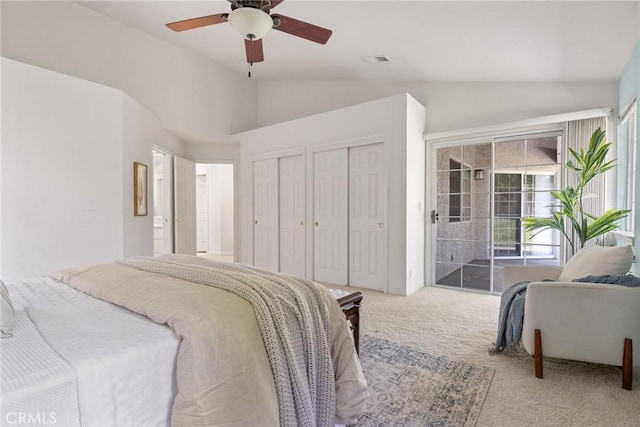 bedroom featuring access to outside, visible vents, multiple closets, carpet, and vaulted ceiling