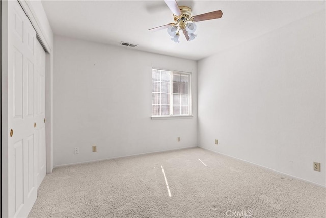 unfurnished bedroom featuring carpet flooring, baseboards, visible vents, and a closet