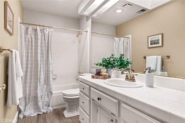 bathroom featuring shower / bath combo, vanity, toilet, wood finished floors, and visible vents