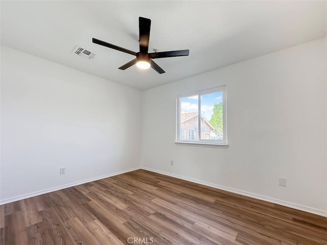 spare room with visible vents, baseboards, ceiling fan, and wood finished floors