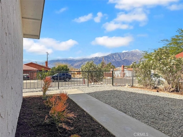 view of yard featuring fence and a mountain view