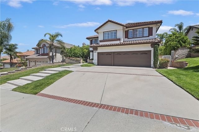 mediterranean / spanish home with a garage, stucco siding, a tile roof, fence, and driveway