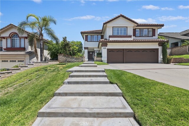 mediterranean / spanish-style house featuring stucco siding, driveway, a tile roof, and a garage