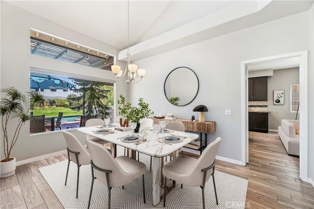 dining room with vaulted ceiling, baseboards, light wood-style flooring, and a notable chandelier