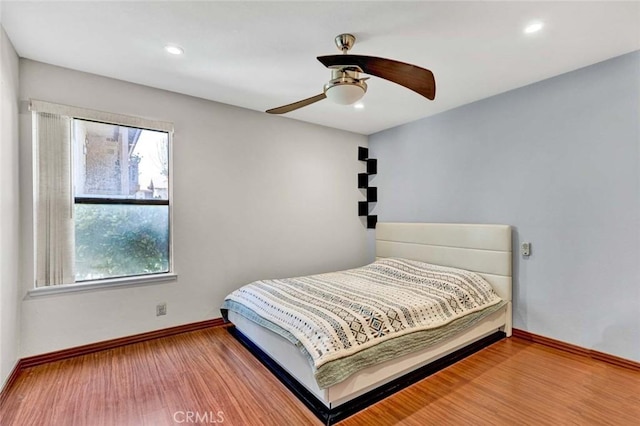 bedroom featuring baseboards, multiple windows, recessed lighting, and wood finished floors