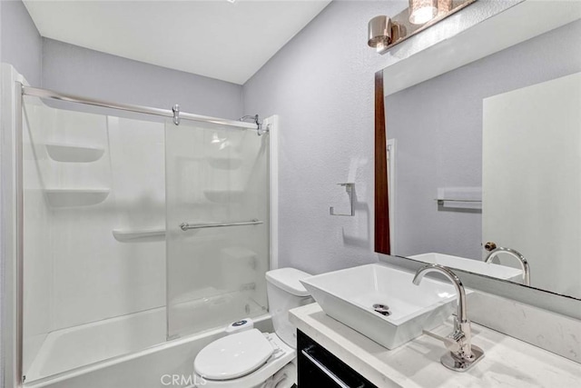 bathroom featuring vanity, shower / bath combination with glass door, and toilet