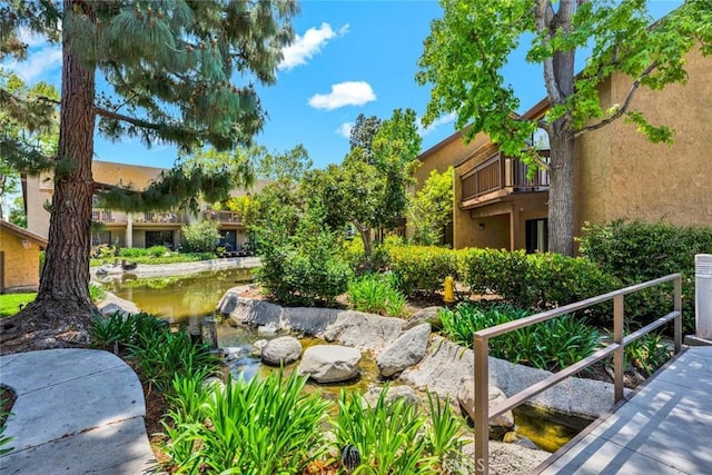 view of home's community featuring a garden pond