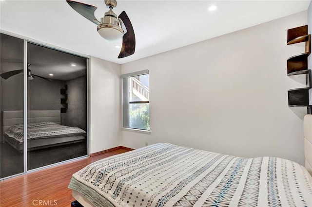 bedroom featuring a ceiling fan, wood finished floors, baseboards, a closet, and recessed lighting