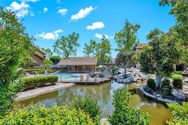 view of dock with a community pool and fence