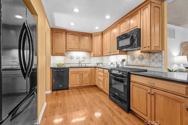 8212 Reading Ave, Los Angeles, CA 90045 - kitchen with black appliances, light wood-type flooring, decorative backsplash, a sink, and recessed lighting