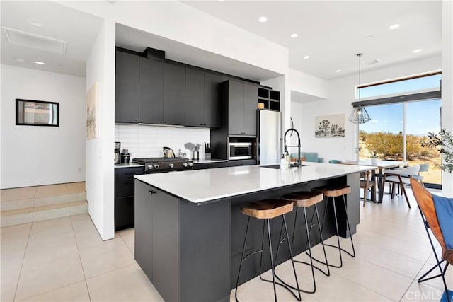 kitchen with dark cabinetry, light countertops, a spacious island, and a kitchen bar
