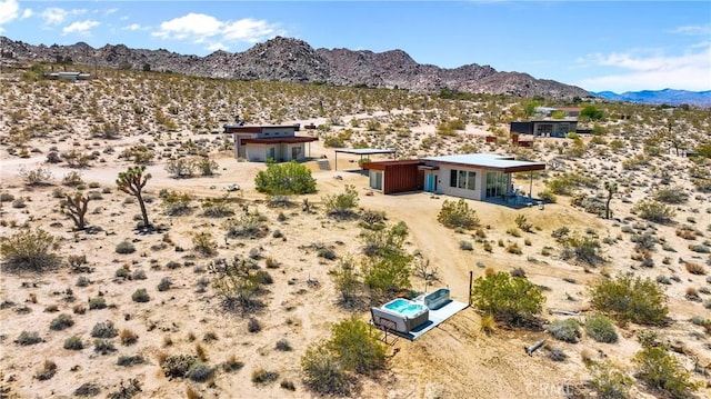 aerial view featuring a mountain view, view of desert, and a rural view