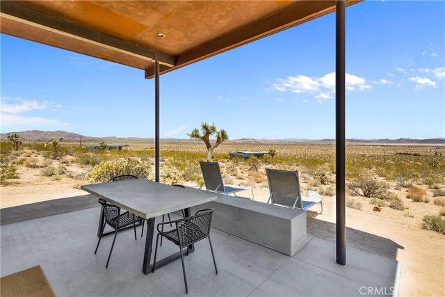 view of patio featuring a rural view, a mountain view, and a desert view