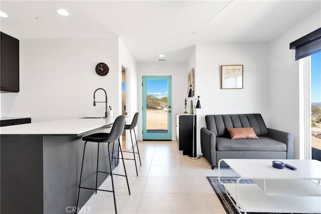 living room featuring recessed lighting, light tile patterned flooring, and visible vents