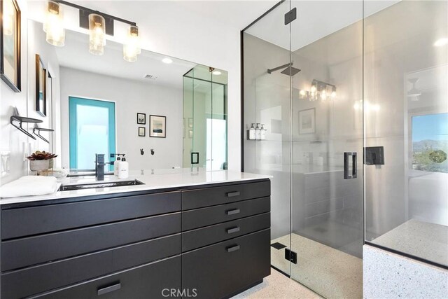 full bathroom featuring vanity, speckled floor, visible vents, and a shower stall