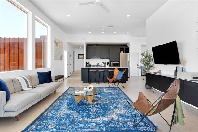 living area with visible vents, ceiling fan, light tile patterned floors, and a healthy amount of sunlight